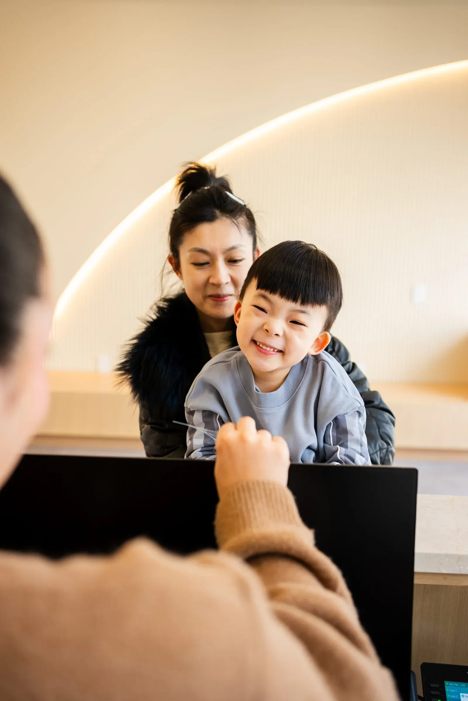 Happy child with mother during dental visit, reinforcing trust, comfort, and a supportive family-centered pediatric care.