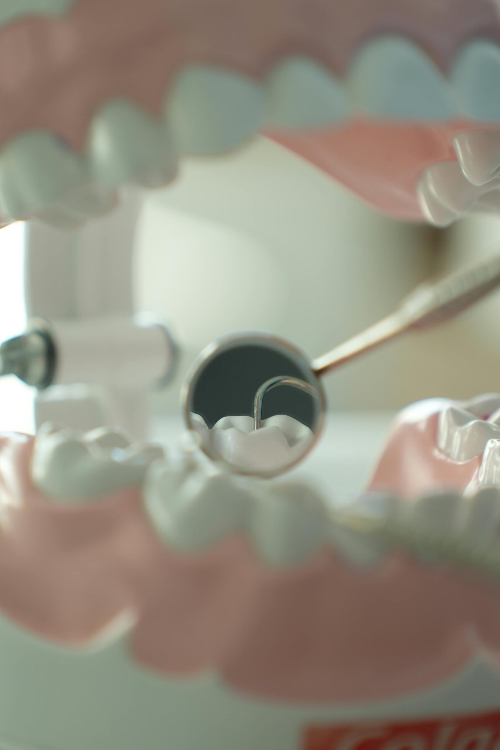 Close-up perspective from dental chair showing patient view with dental tools and overhead light during procedure.