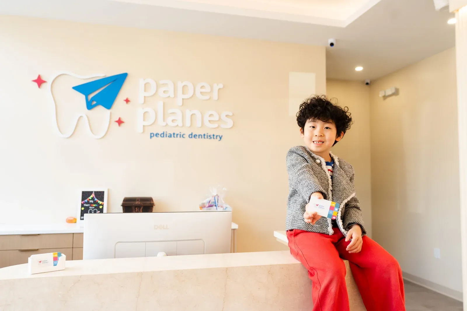 Young boy at the reception area, showing welcoming front desk experience at a pediatric dental office.
